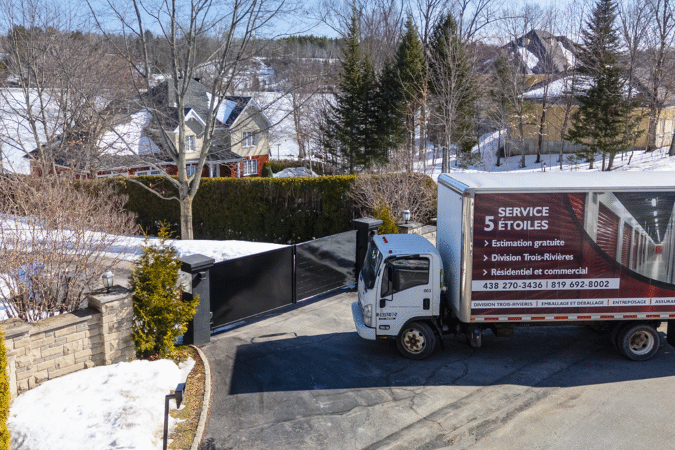 Le camion de déménagement Transport Five Star dans un quartier résidentiel, lors d'un déménagement.