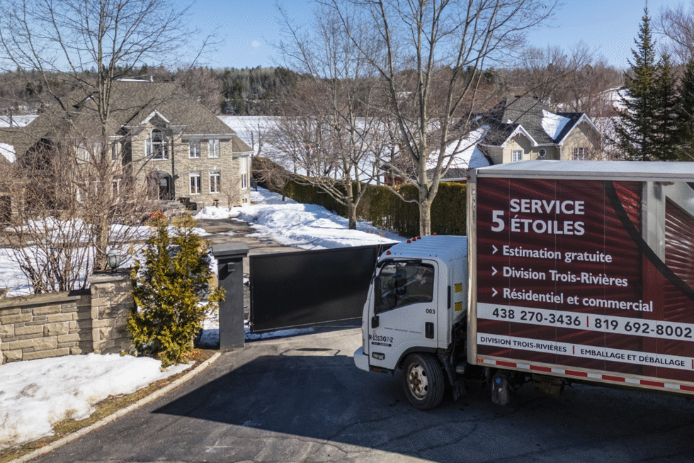 Le camion de déménagement de Transport Five Star, devant une maison québécoise avec à l'arrière, un lac.