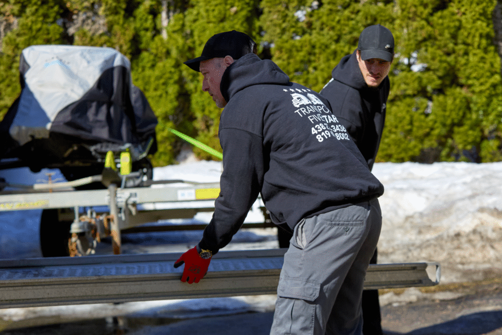 À l'arrière du camion, les déménageurs rangent les rampent d'accès au camion de déménagement.