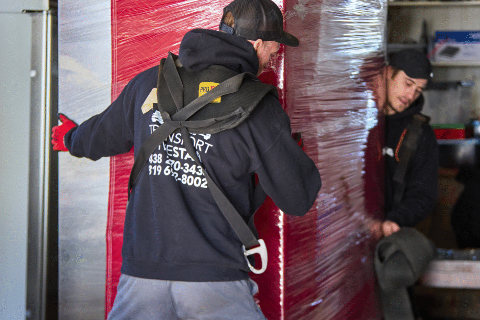 Deux de nos déménageurs en train de porter un meuble volumineux.