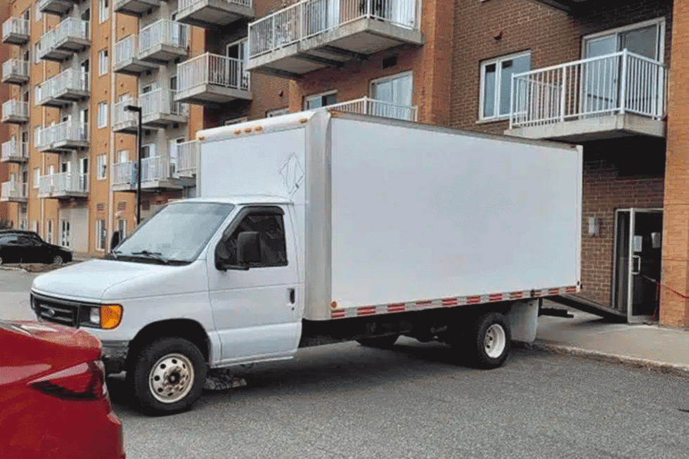 Camion de déménagement garé devant un immeuble pour un déménagement.